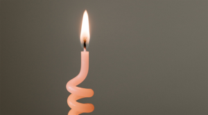 a spiral shaped thin candle burning. Photo. 