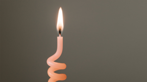 a spiral shaped thin candle burning. Photo.
